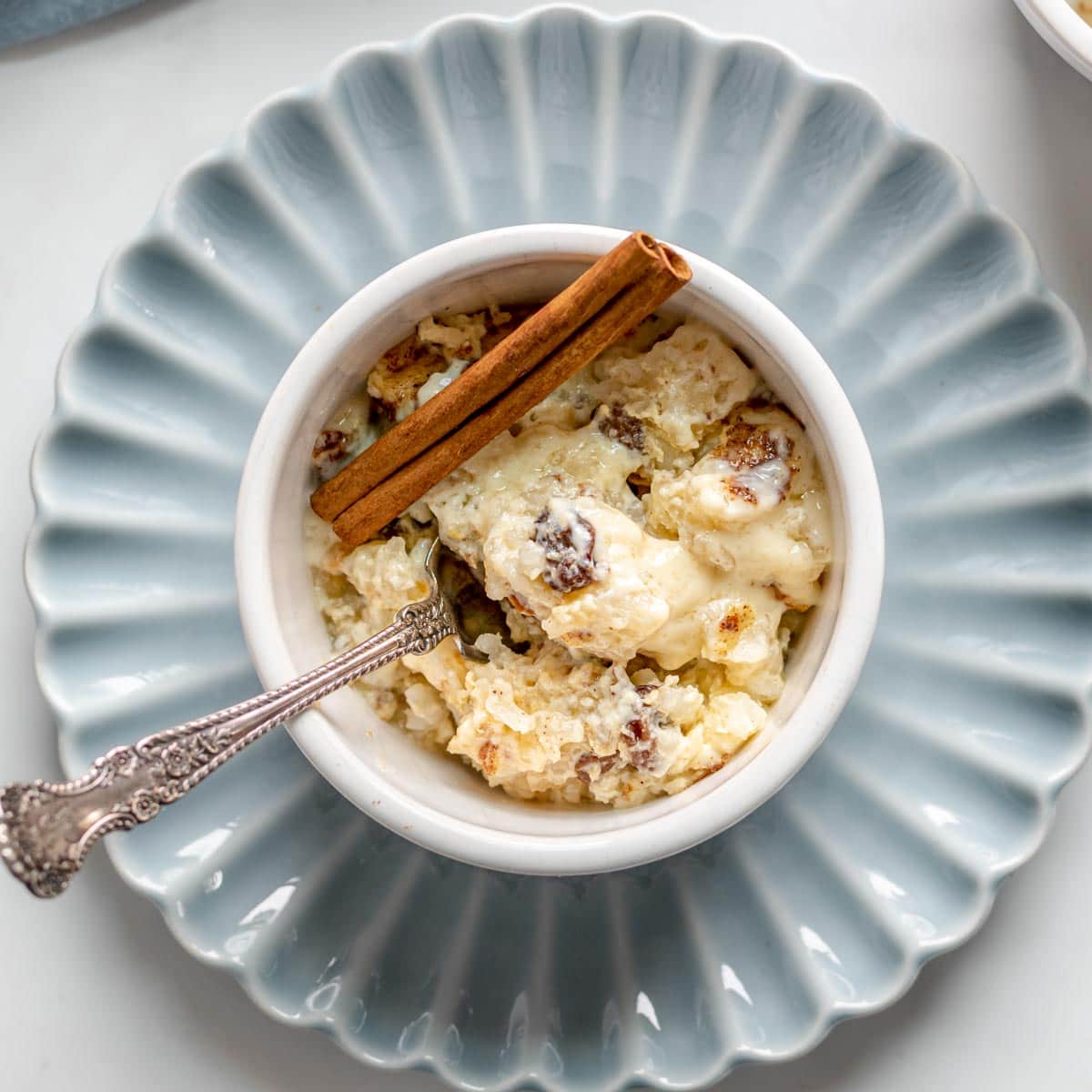 Baked Rice Pudding served in a ramekins on a light blue scalloped plate
