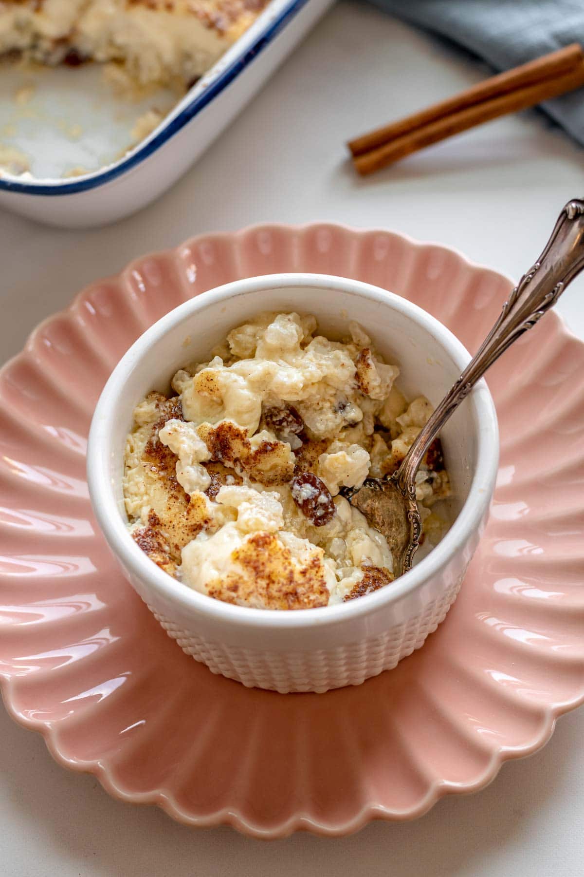 Baked Rice Pudding served in a ramekins on a pink plate