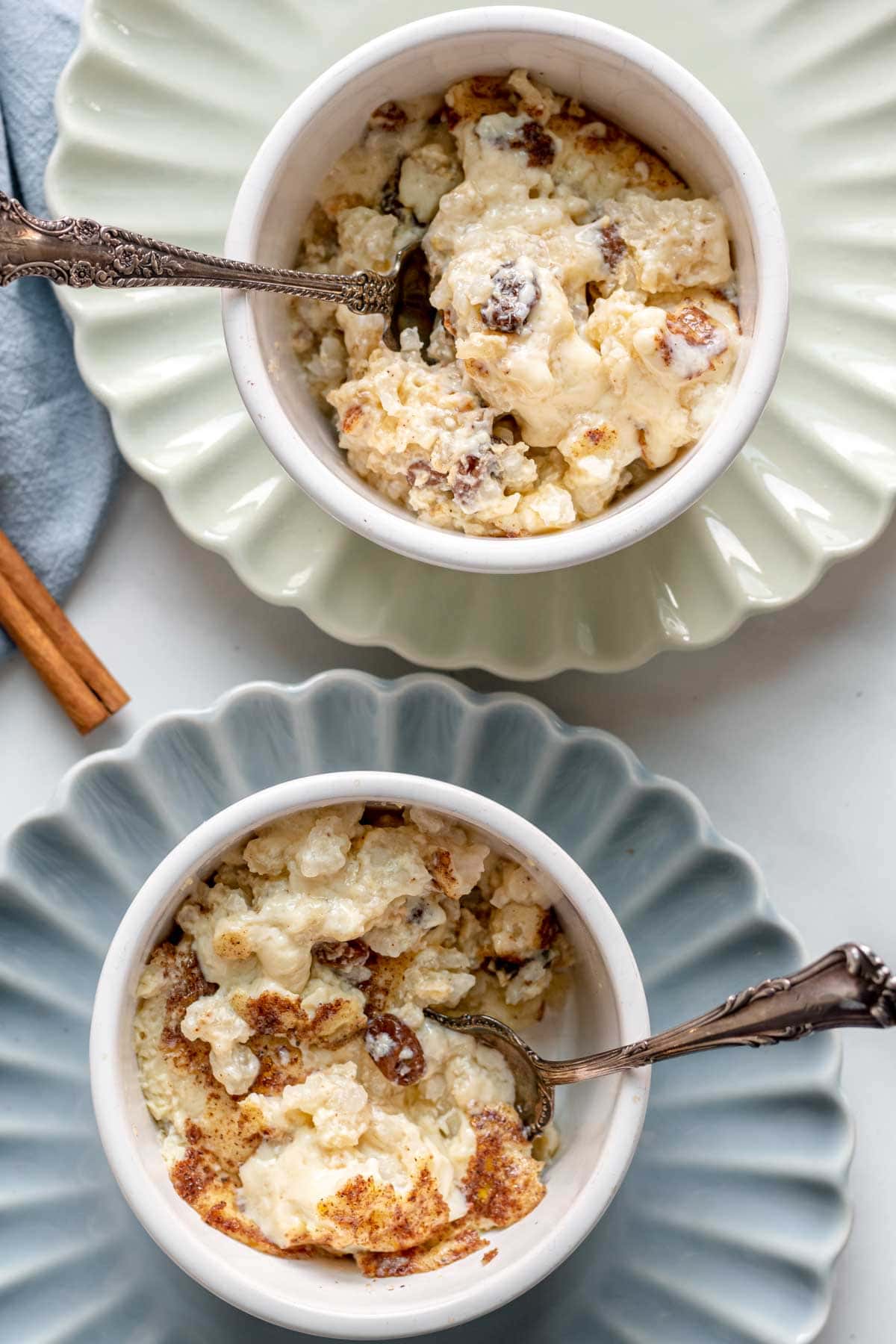 Baked Rice Pudding served in two ramekins on blue and white plates