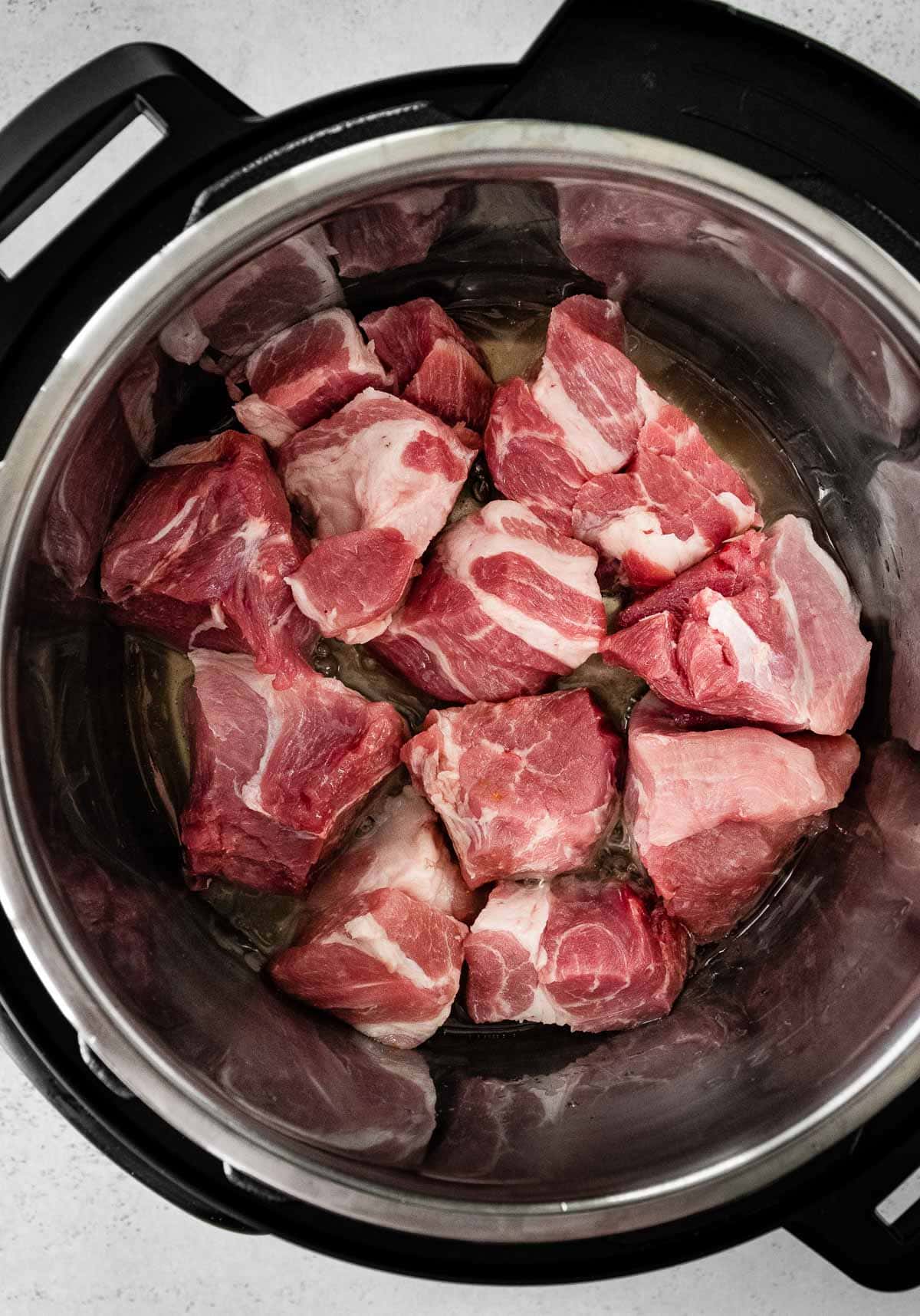 Instant Pot Pork Carnitas uncooked pork pieces in instant pot
