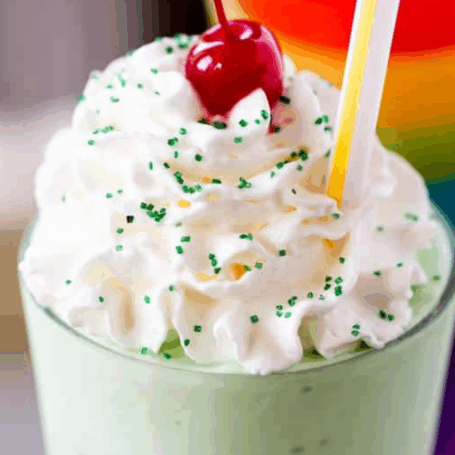shake in a glass with whipped cream and cherry on top