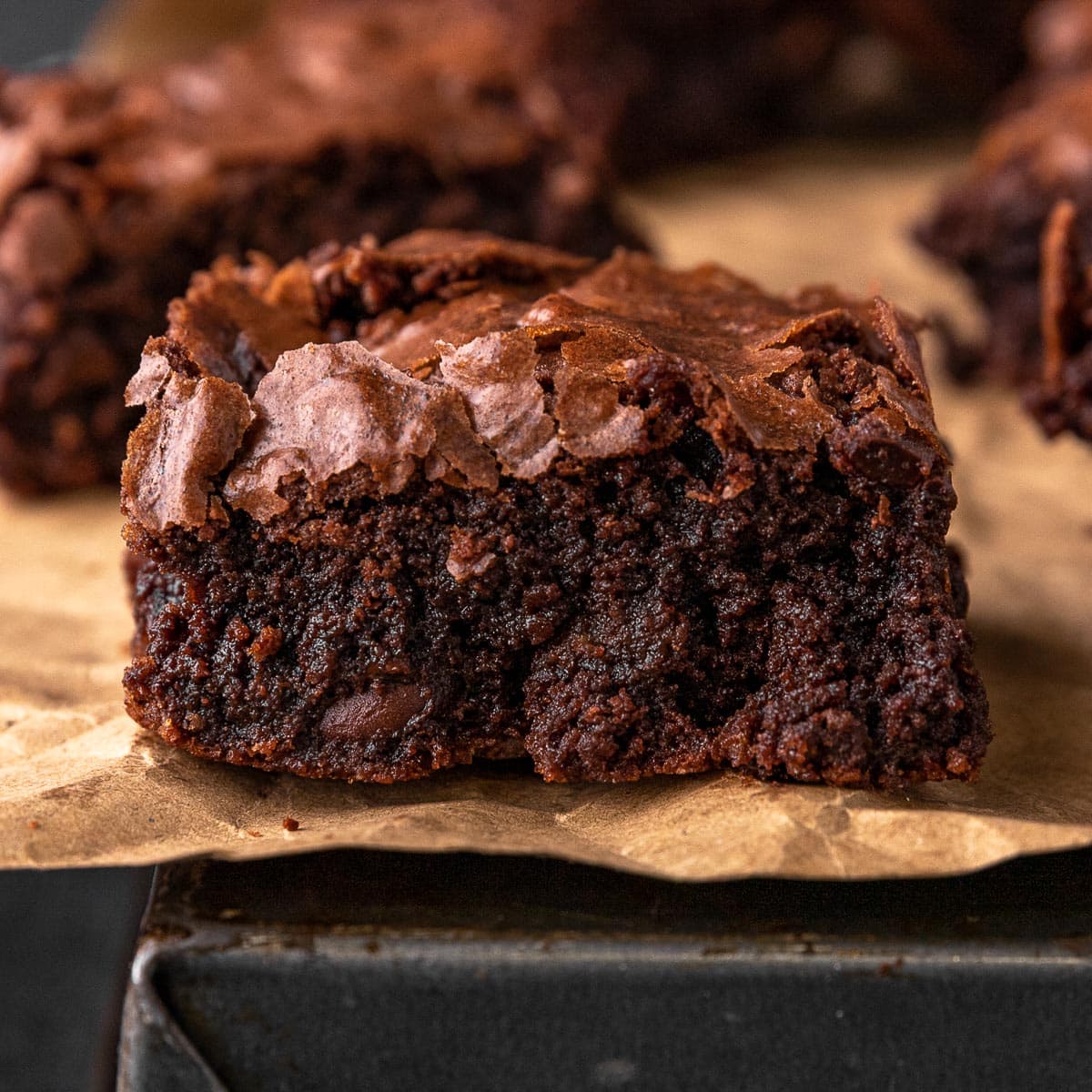 Super Rich Chocolate Brownies close up on a baked brownie on parchment paper