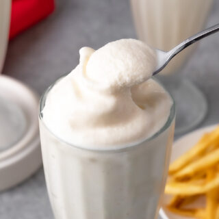 Frosty in a milkshake glass with a spoon