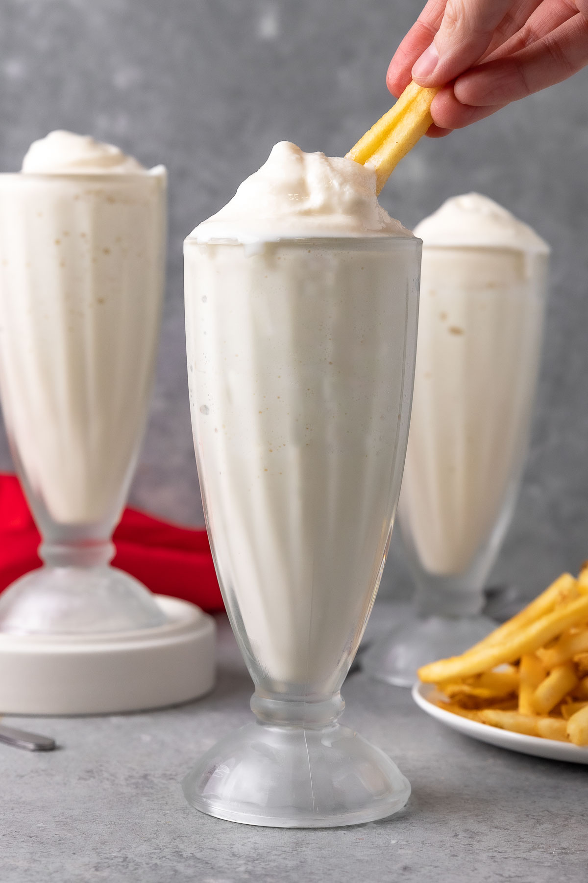 Wendys Vanilla Frosty multiple frosties in a milkshake glasses, dipping fry in one frosty