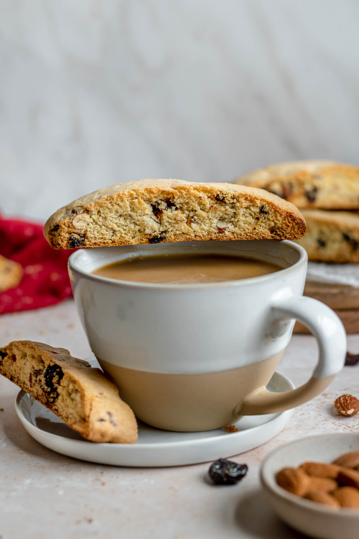 Cherry Almond Biscotti baked cookies resting on coffee cup and saucer