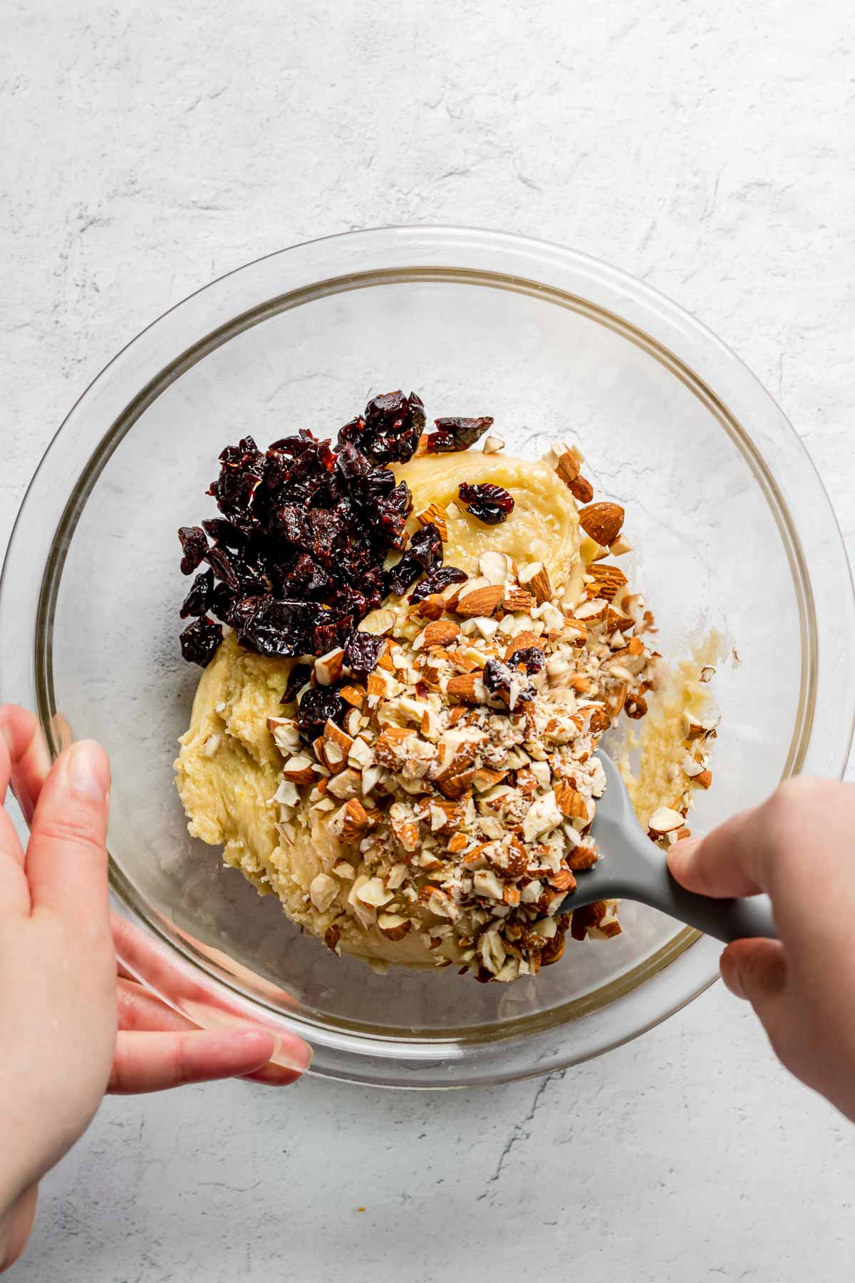 Cherry Almond Biscotti stirring cherries and almonds into dough in glass bowl