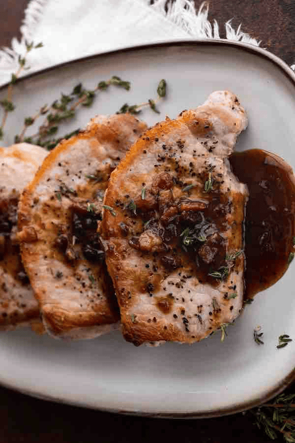 Close up of pork chops served on a white platter