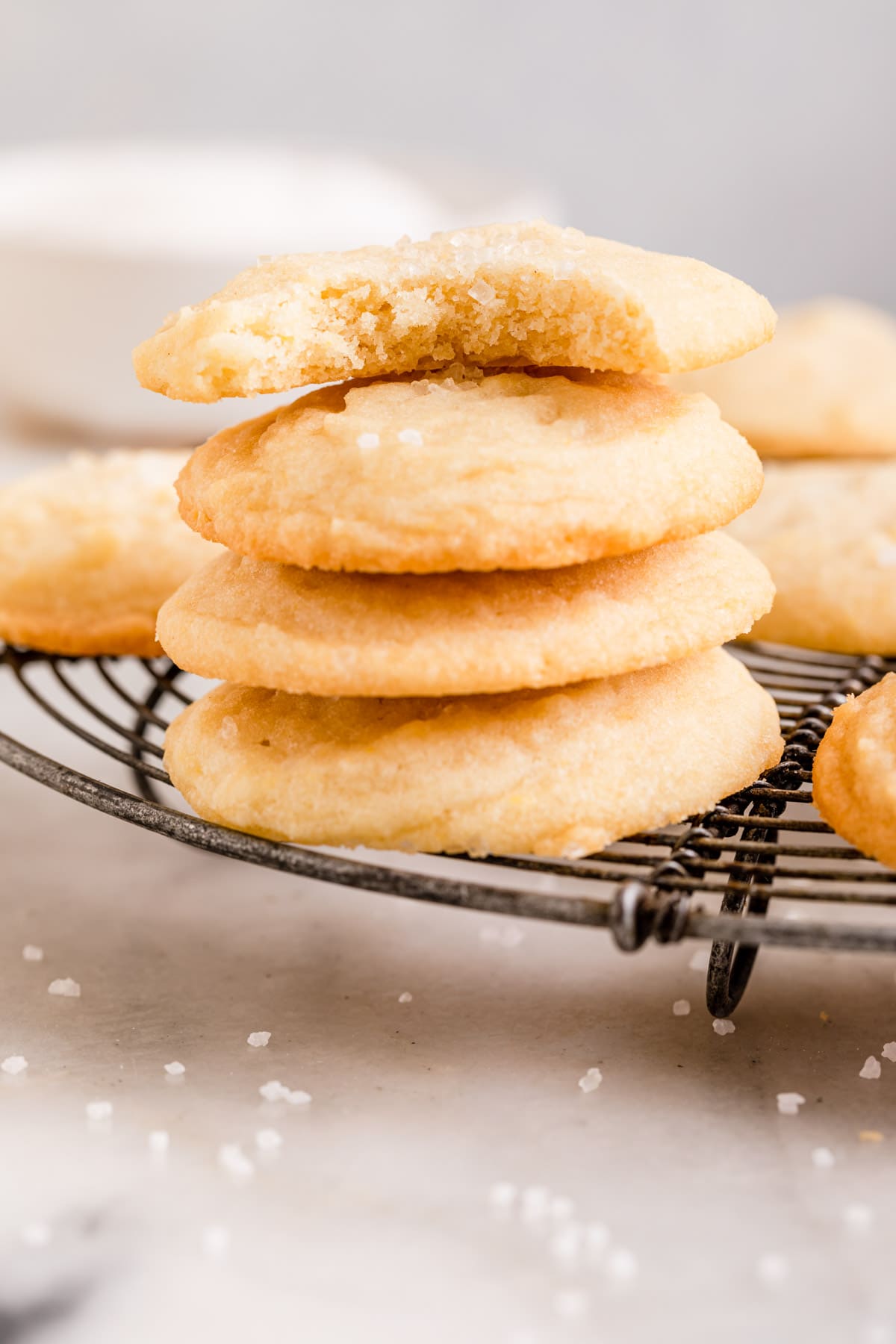 Amish Sugar Cookies baked cookies in stack on cooling rack with bite taken out of top cookie