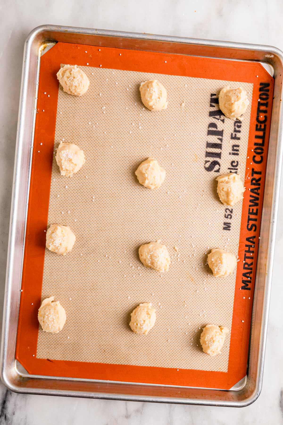 Amish Sugar Cookies dough balls on silpat on baking sheet before baking