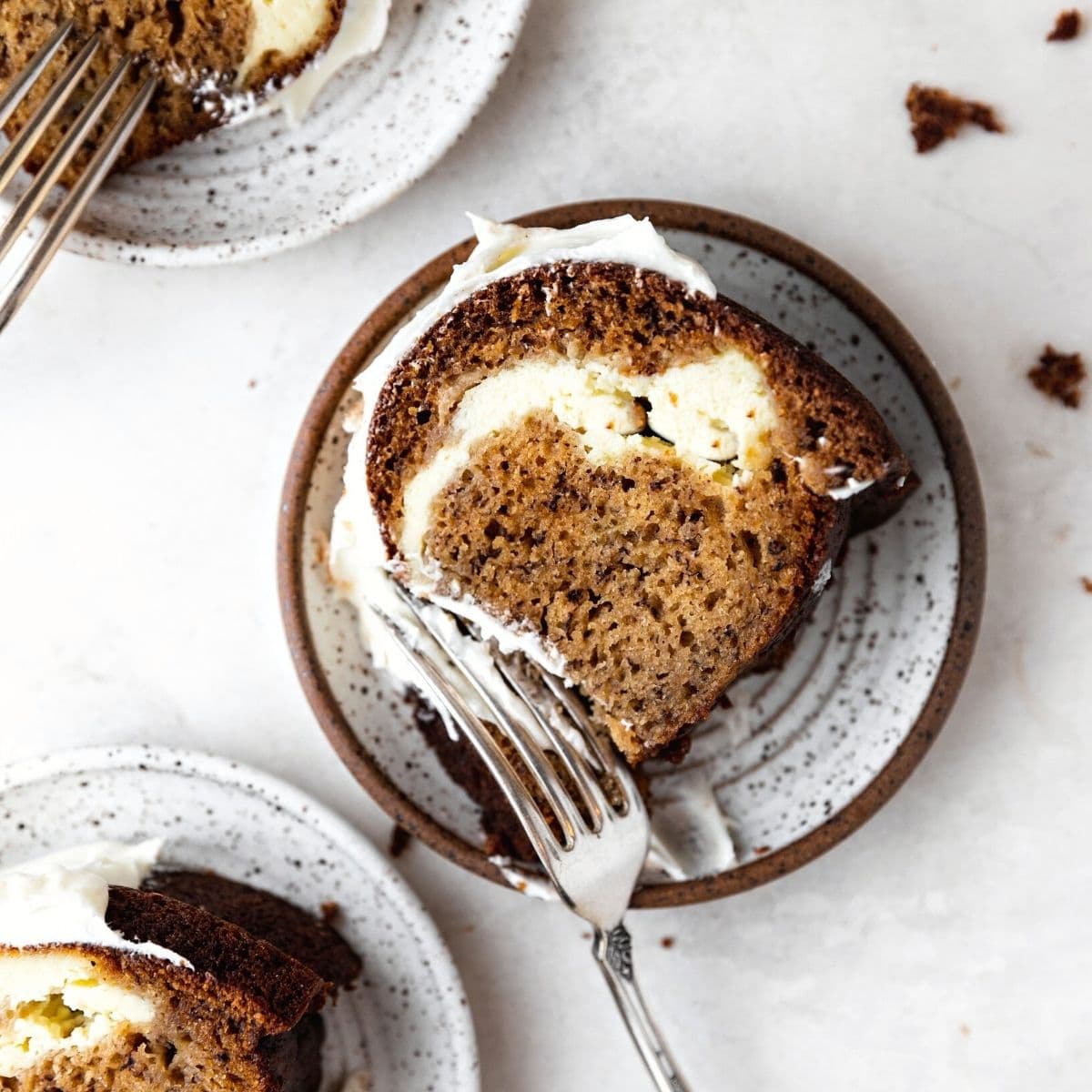 Banana Cheesecake Bundt Cake finished slice on plate with fork cutting bite