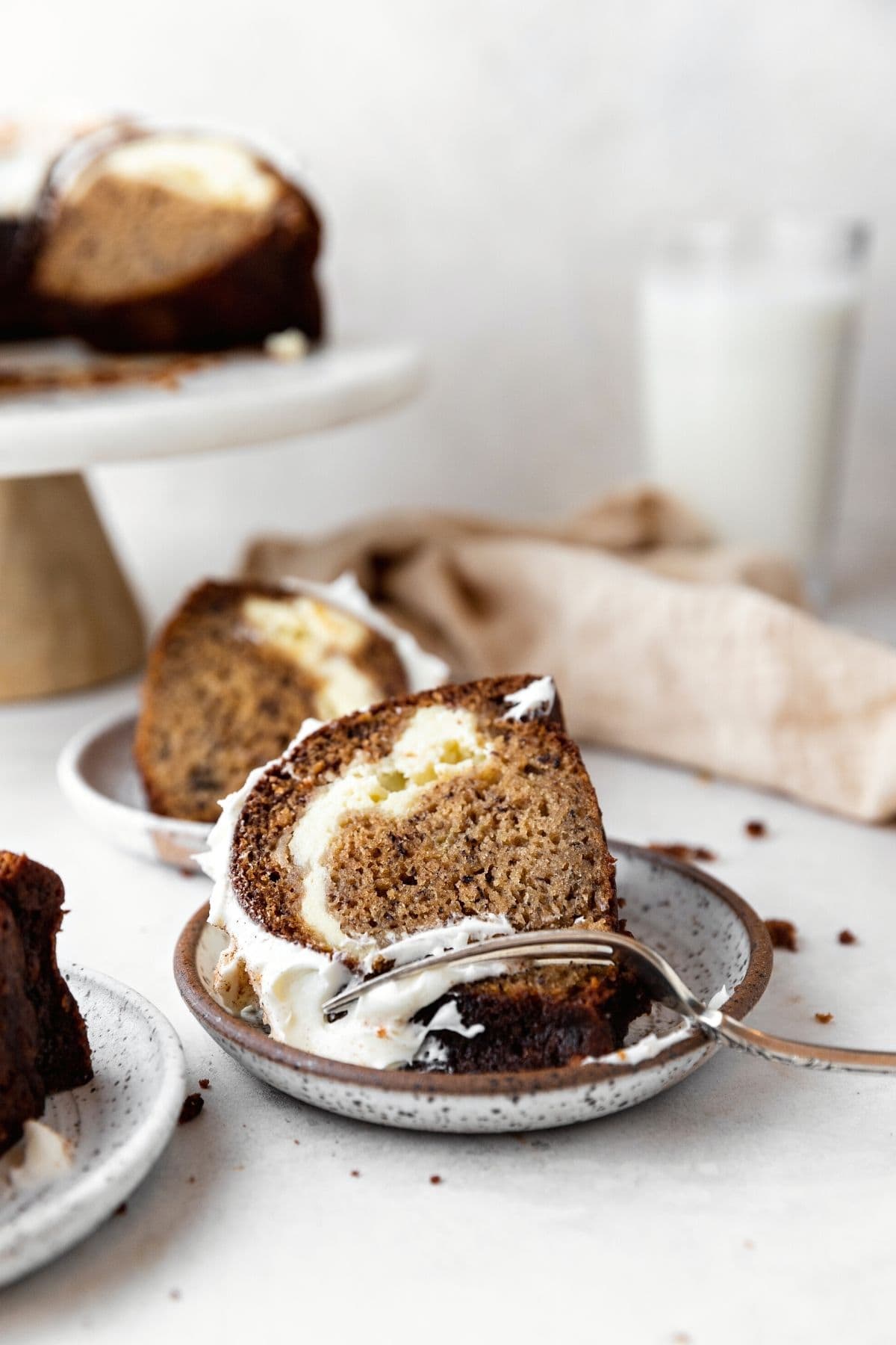 Banana Cheesecake Bundt Cake finished slice on plate with slices in background