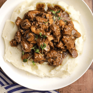 beef in gravy on top of mashed potatoes