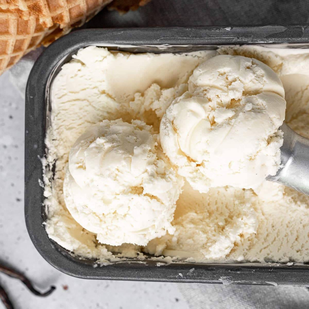 French Vanilla Ice Cream finished in loaf pan with scoops of ice cream and scoop on top