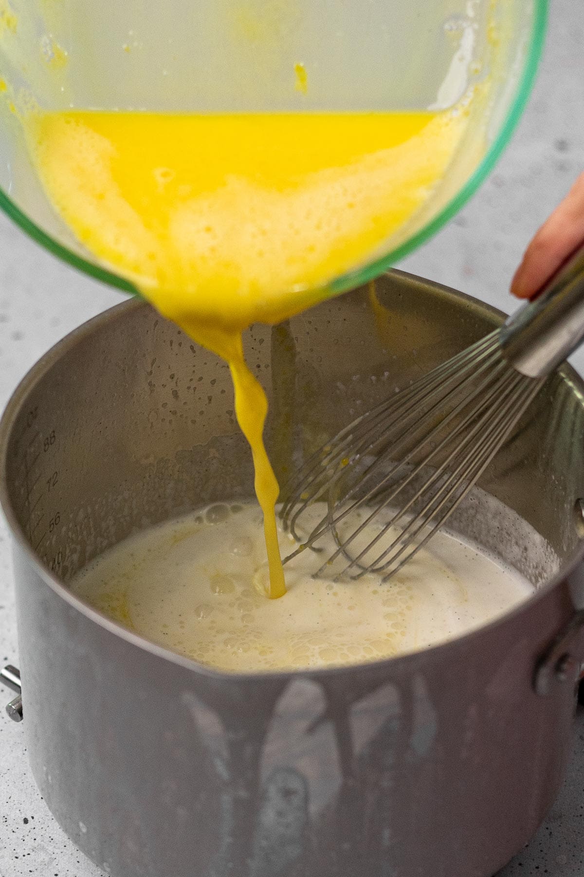 French Vanilla Ice Cream whisking egg yolks into cream mixture in sauce pan