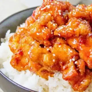 Side view of chicken in bowl served over rice
