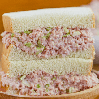 ground pork, celery, and mayo mixture in between two slices of bread stacked on one another