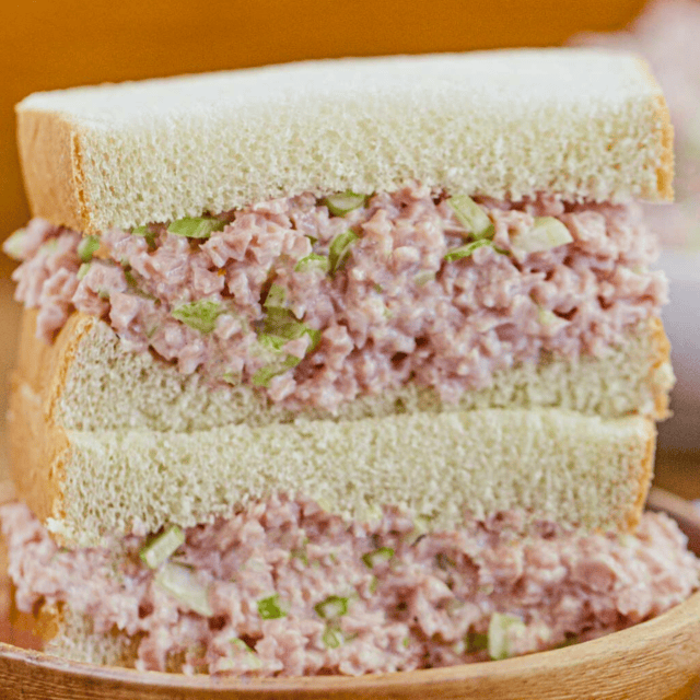 ground pork, celery, and mayo mixture in between two slices of bread stacked on one another