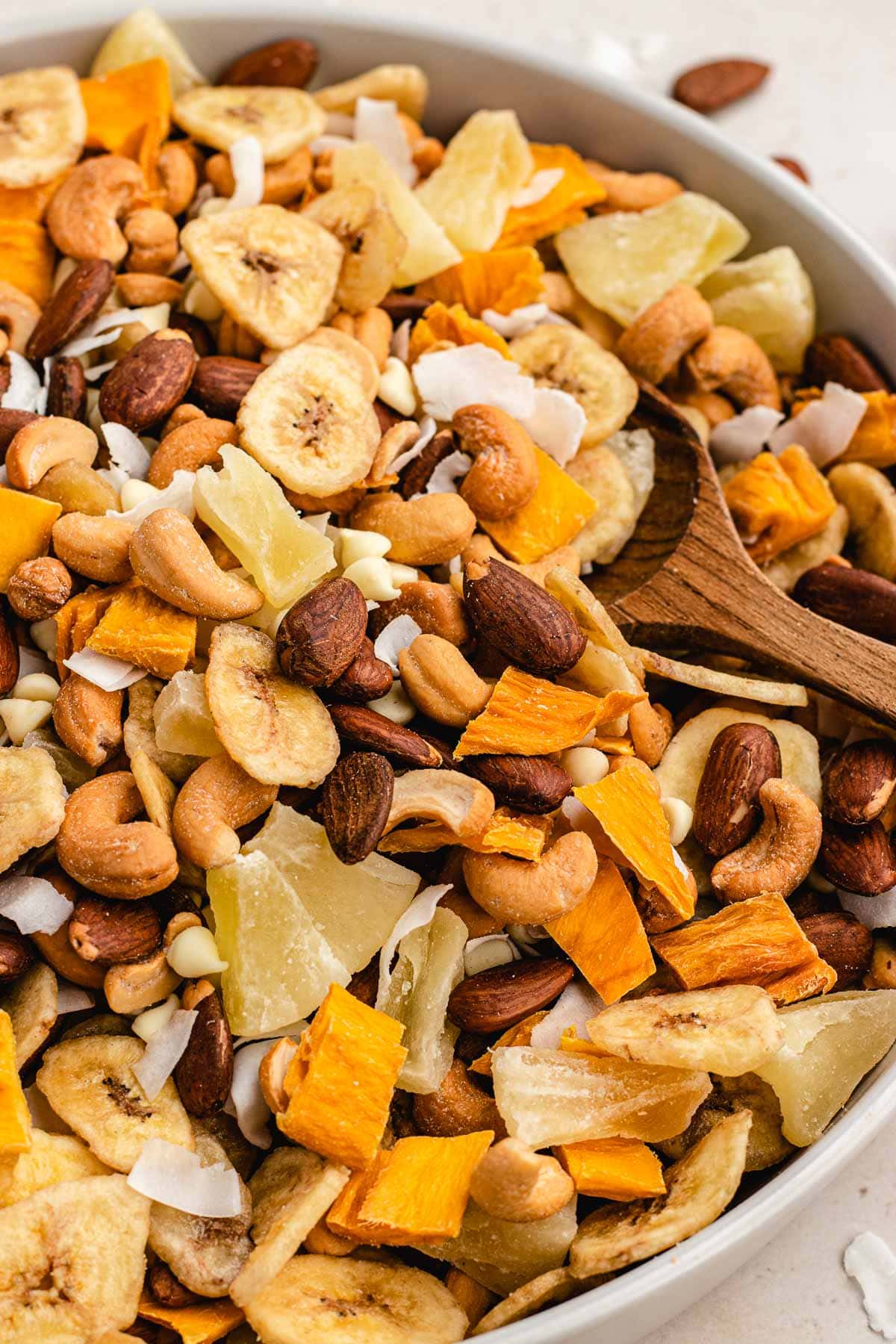 Tropical Trail Mix combined in large bowl with wooden spoon