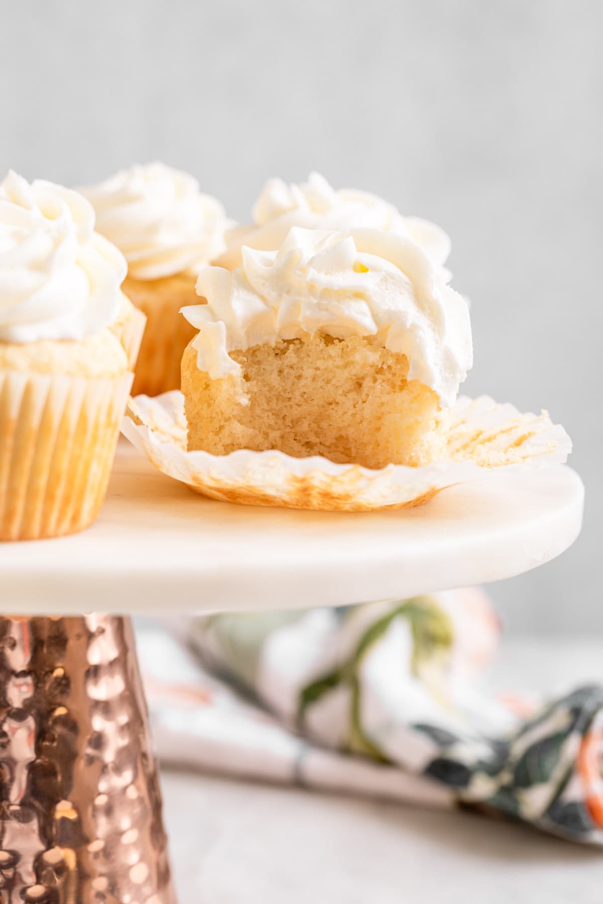 White Cupcakes Wedding Cupcakes frosted cupcakes on cake stand with paper line pulled down and bite take out