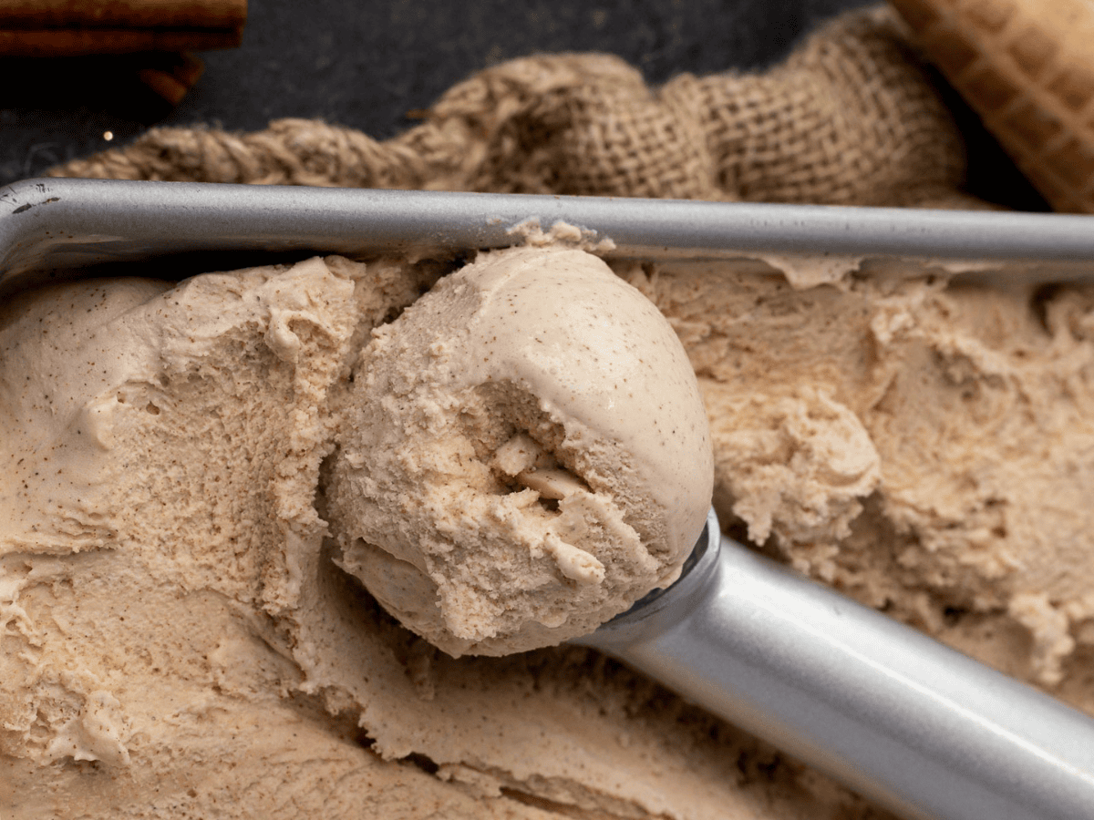 spiced ice cream in metal container with ice cream scooper