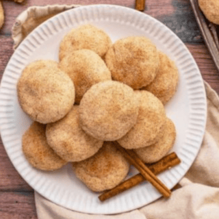 Cinnamon cookies on a white plate with cinnamon sticks