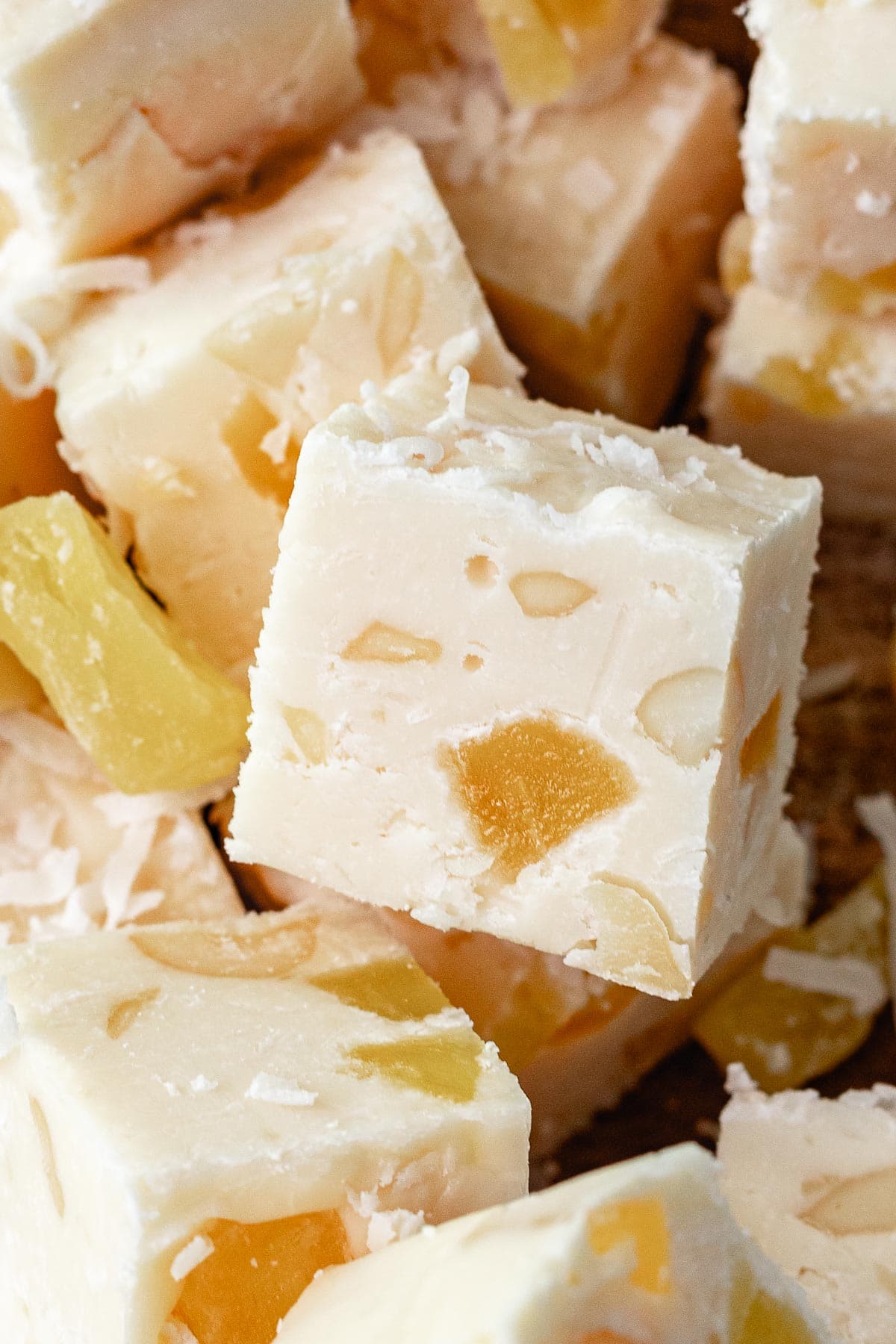 Pina Colada Fudge squares in a pile with close up of one square