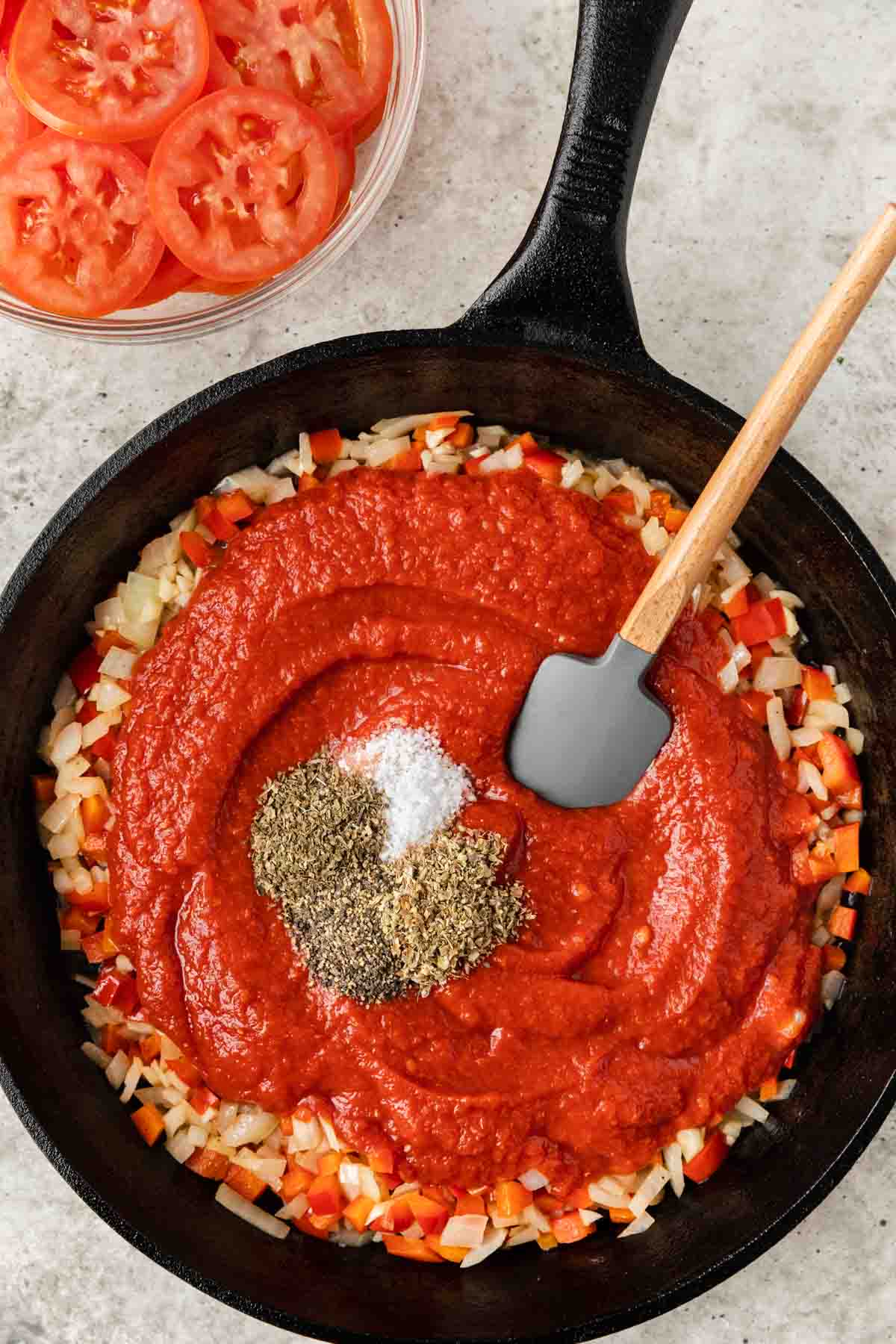 mixing tomato sauce and spices to