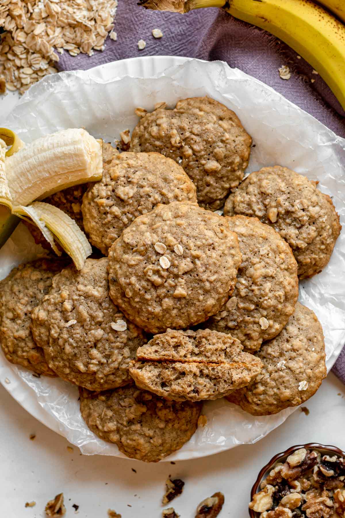 Banana Bread Cookies pile of cookies on plate with half peeled banana off to side and one cookie broken in half at bottom