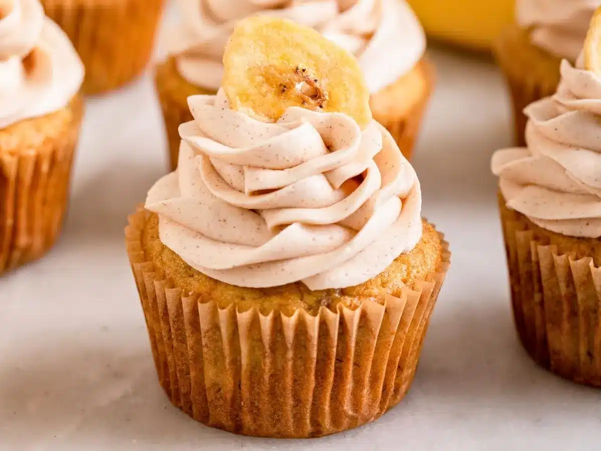 close up of individual sweet treat with frosting and tropical fruit on top