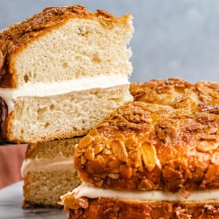 Slice of layer cake with custard, topped with honey and almonds.