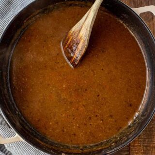 Large sauce pan with gravy and wooden spoon.