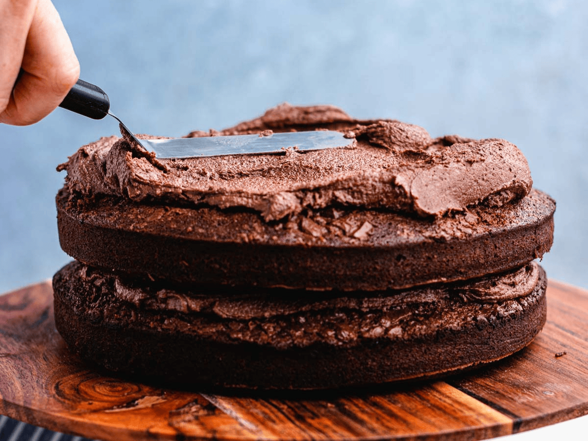 Frosting being spread on top of cake. 