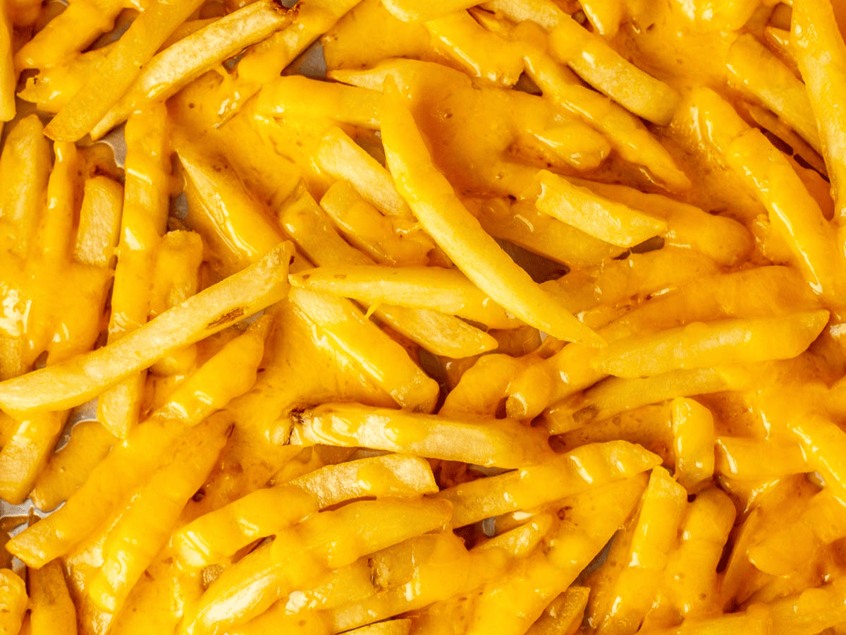 Close up of French fries with melted cheese.