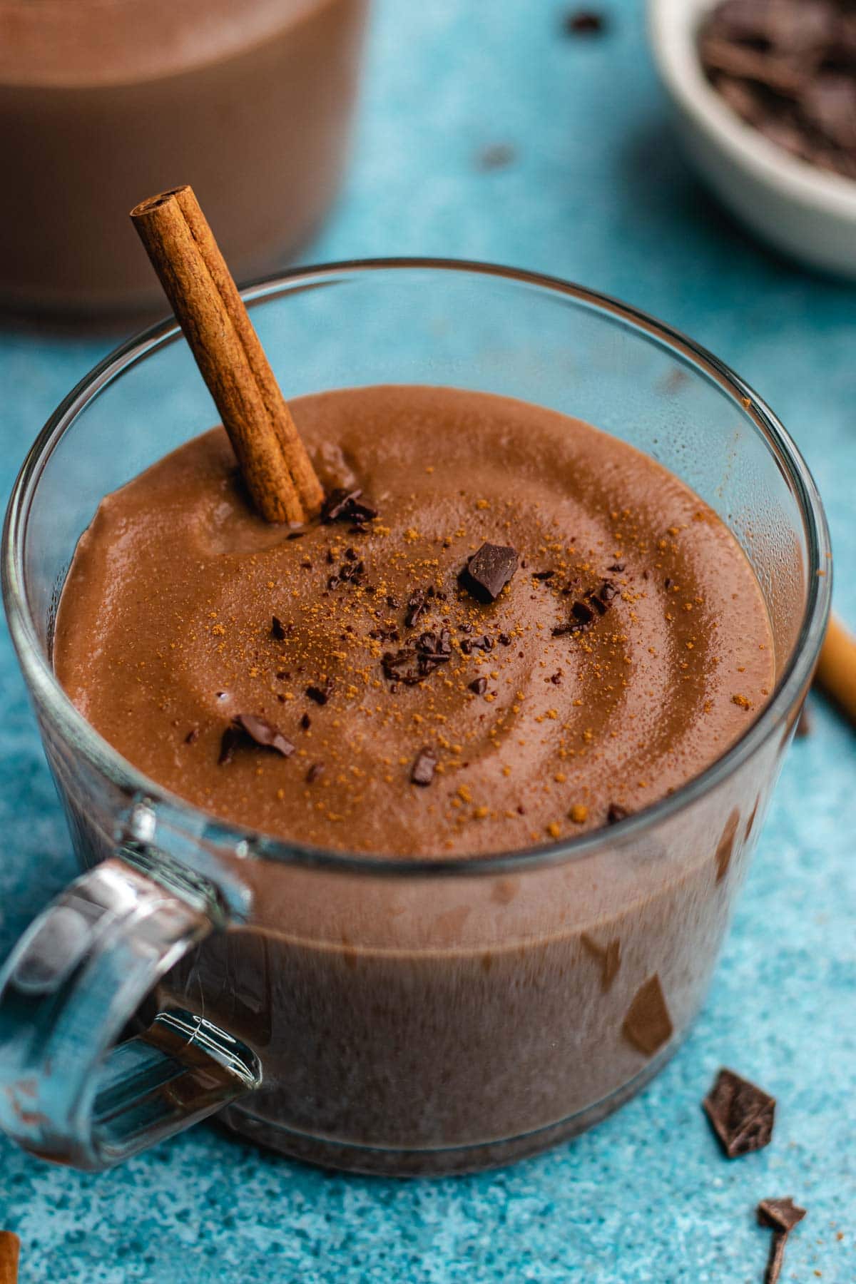 Champurrado finished drink in glass coffee cup with cinnamon stick