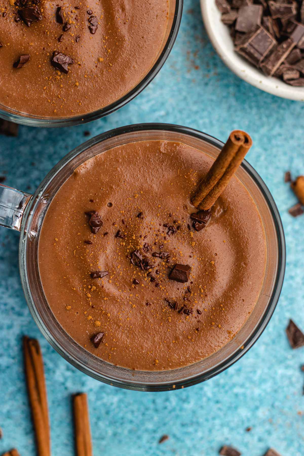 Champurrado finished drink in glass coffee cup with cinnamon stick, top view