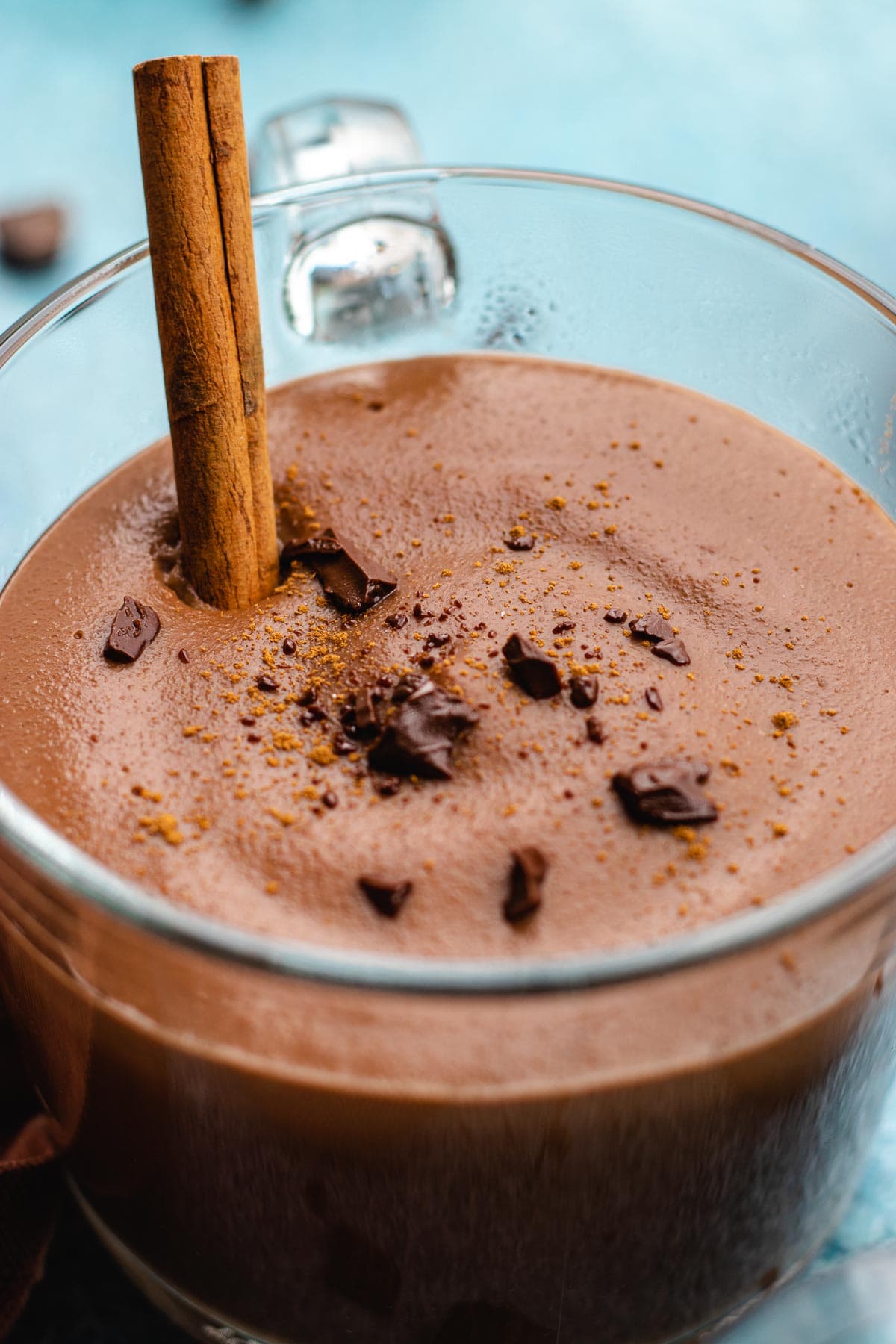 Champurrado finished drink in glass coffee cup with cinnamon stick