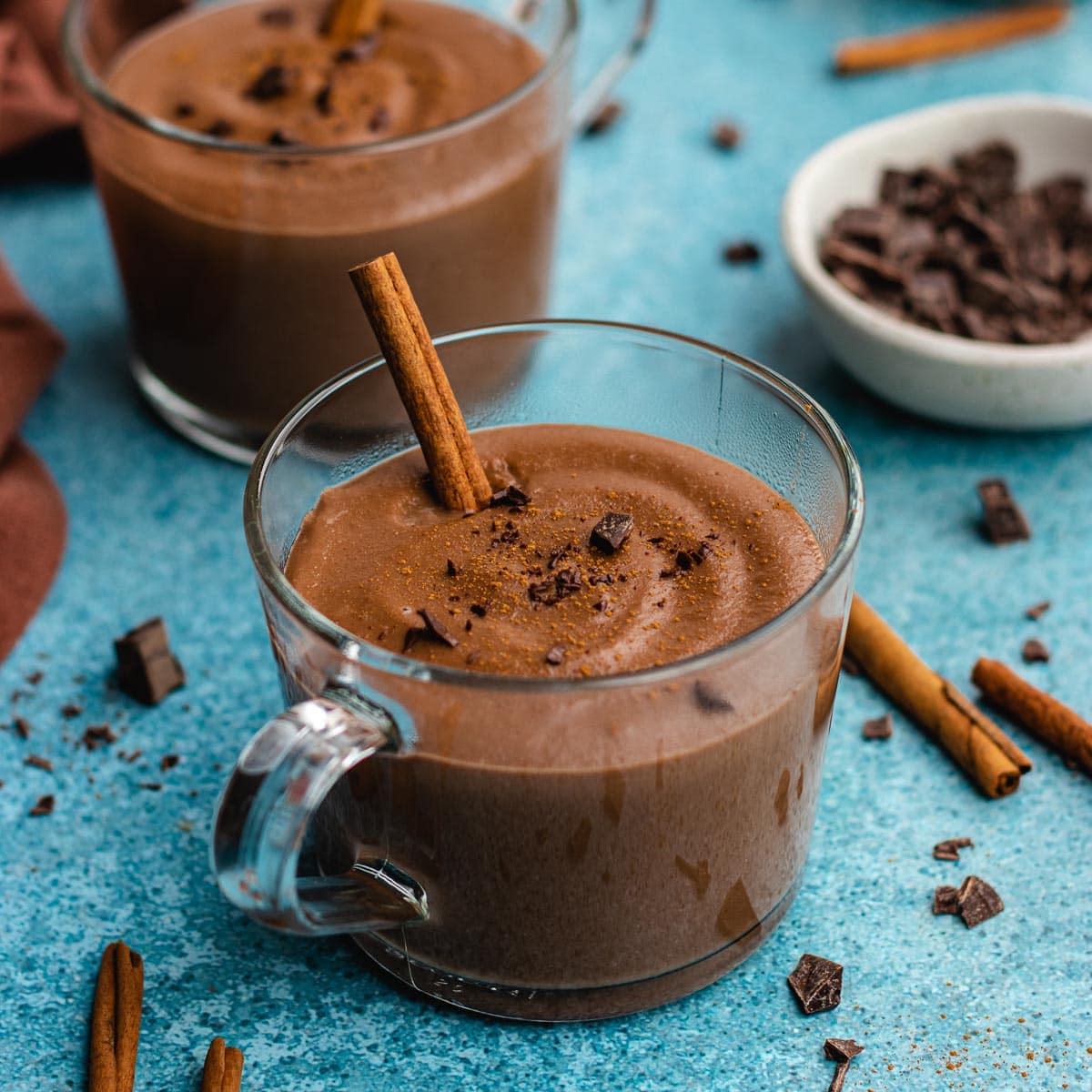 Champurrado finished drink in glass coffee cup with cinnamon stick