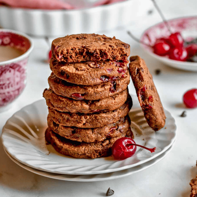 Buttery cocoa stone fruit circular desserts stacked on a white plate with one leaning on the stack