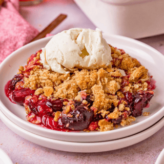 cherries, crunchy oats, and ice cream on top of a white plate