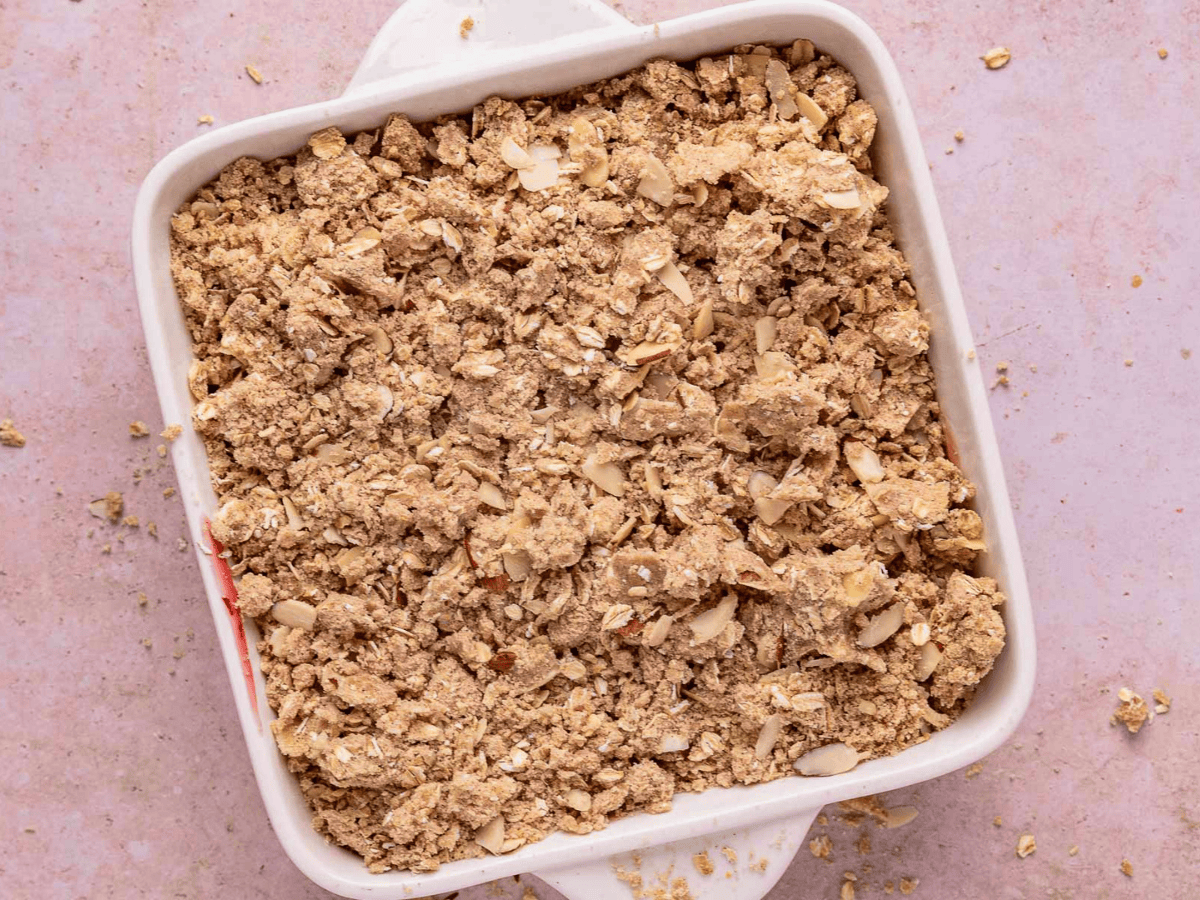 oats and almonds covering a bed of cherries in a baking dish
