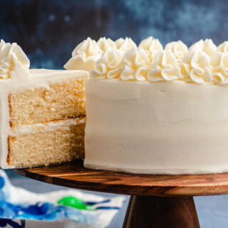 Layer cake on serving plate with slice taken out.