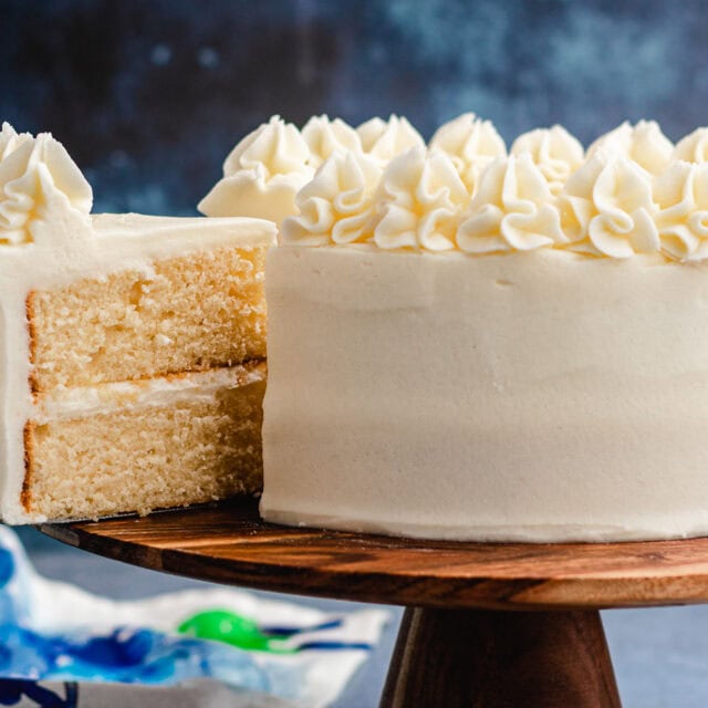Layer cake on serving plate with slice taken out.