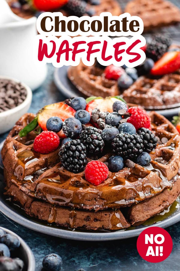 Plate of waffles, topped with syrup and fruit.