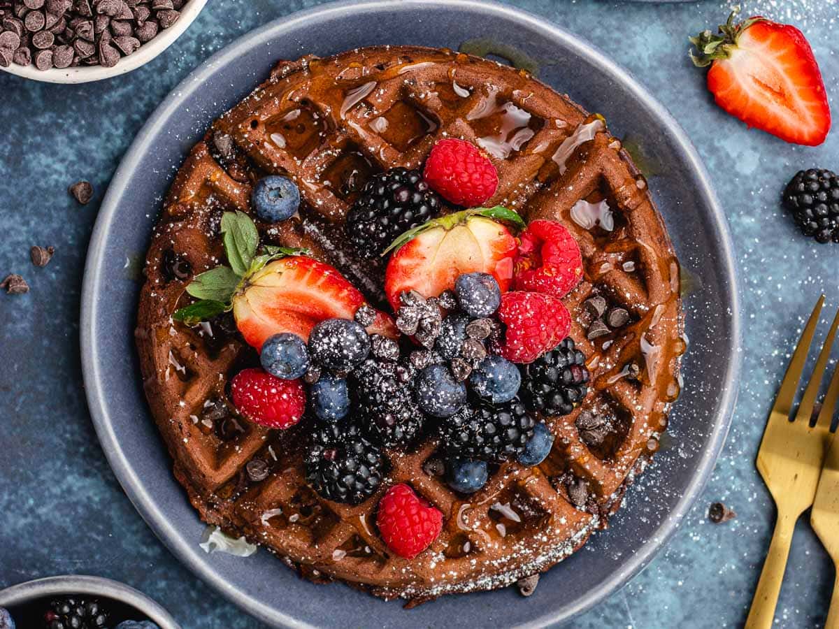 Waffles topped with syrup and fruit.