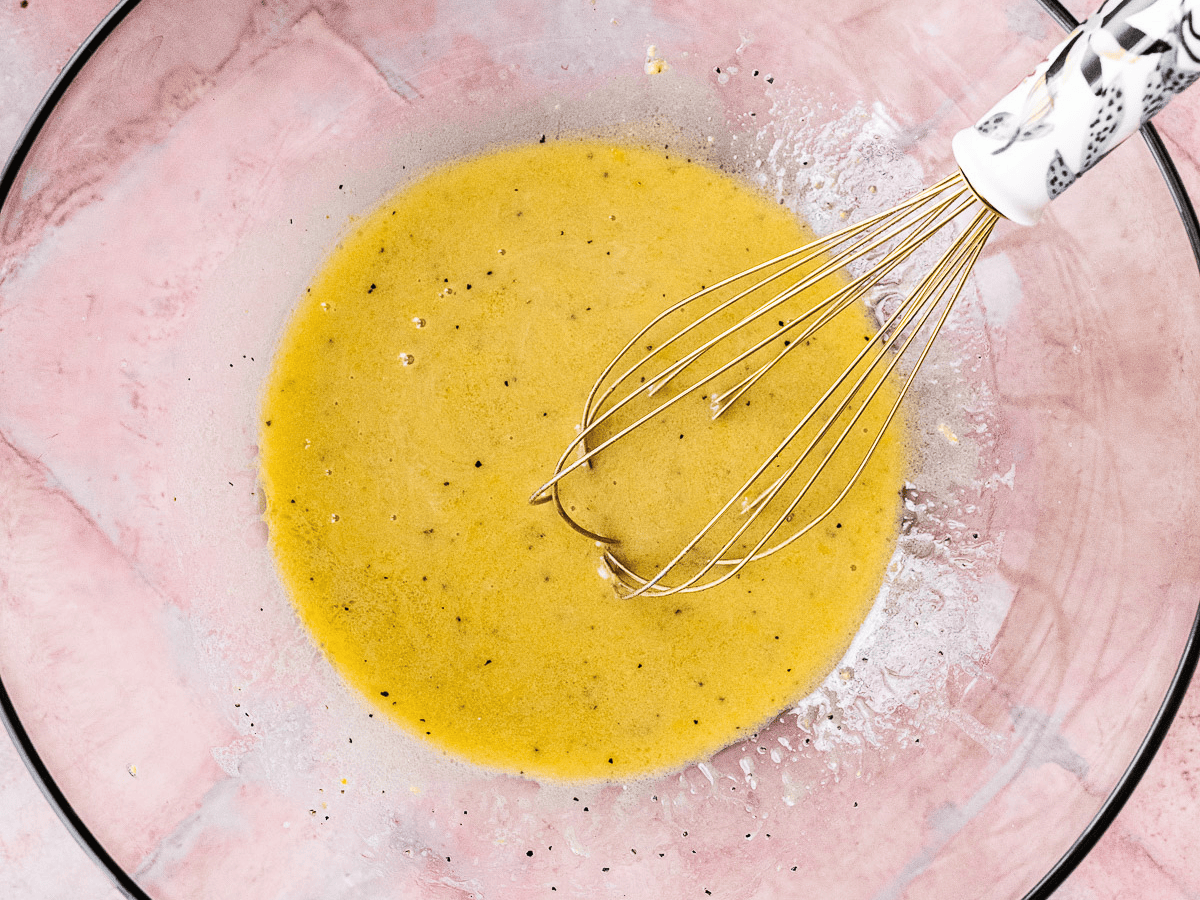 Salad dressing with whisk in bowl.
