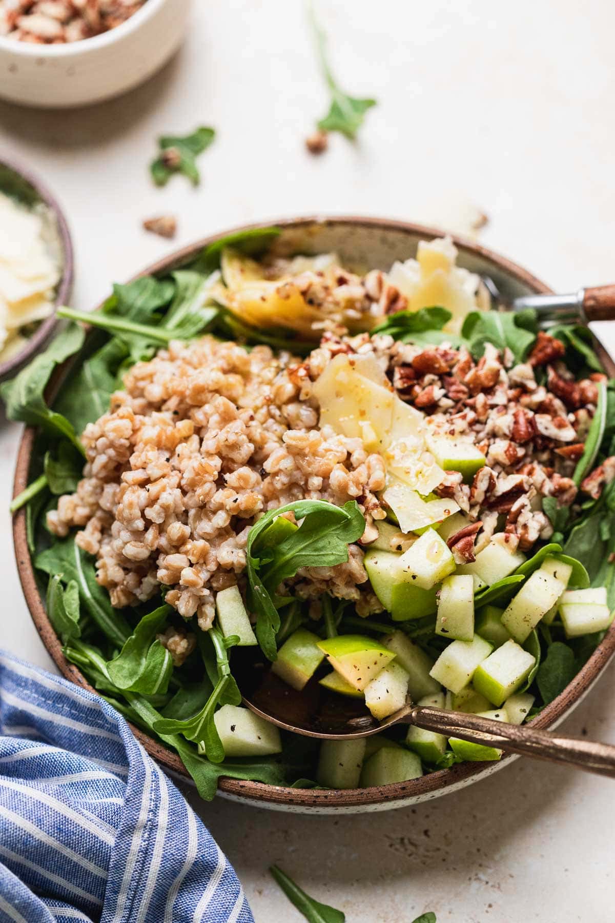 Farro salad on plate with fork and spoon.