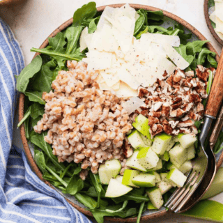 Farro salad on plate with fork and spoon.