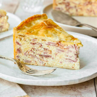 Slice of meat pie on plate with fork