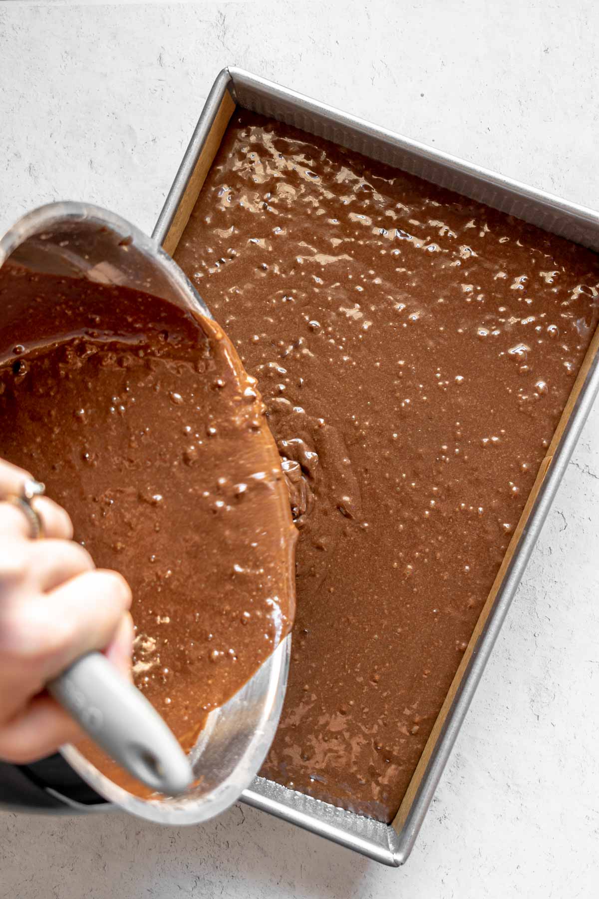 Eggless Chocolate Cake batter being poured in the pan