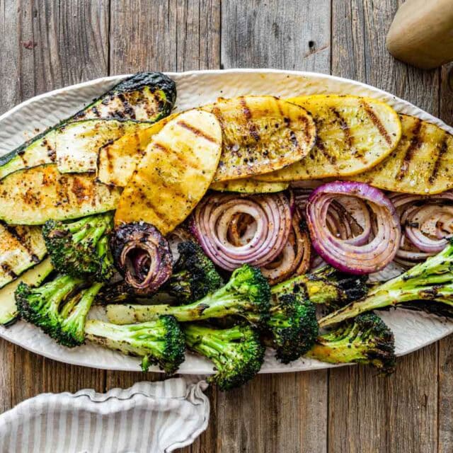 Grilled assorted veggies spread out on serving plate.